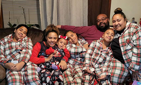Family in matching PJs on couch