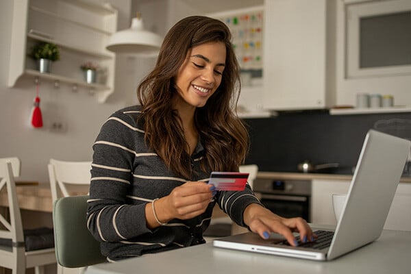 Woman shopping with credit card on laptop