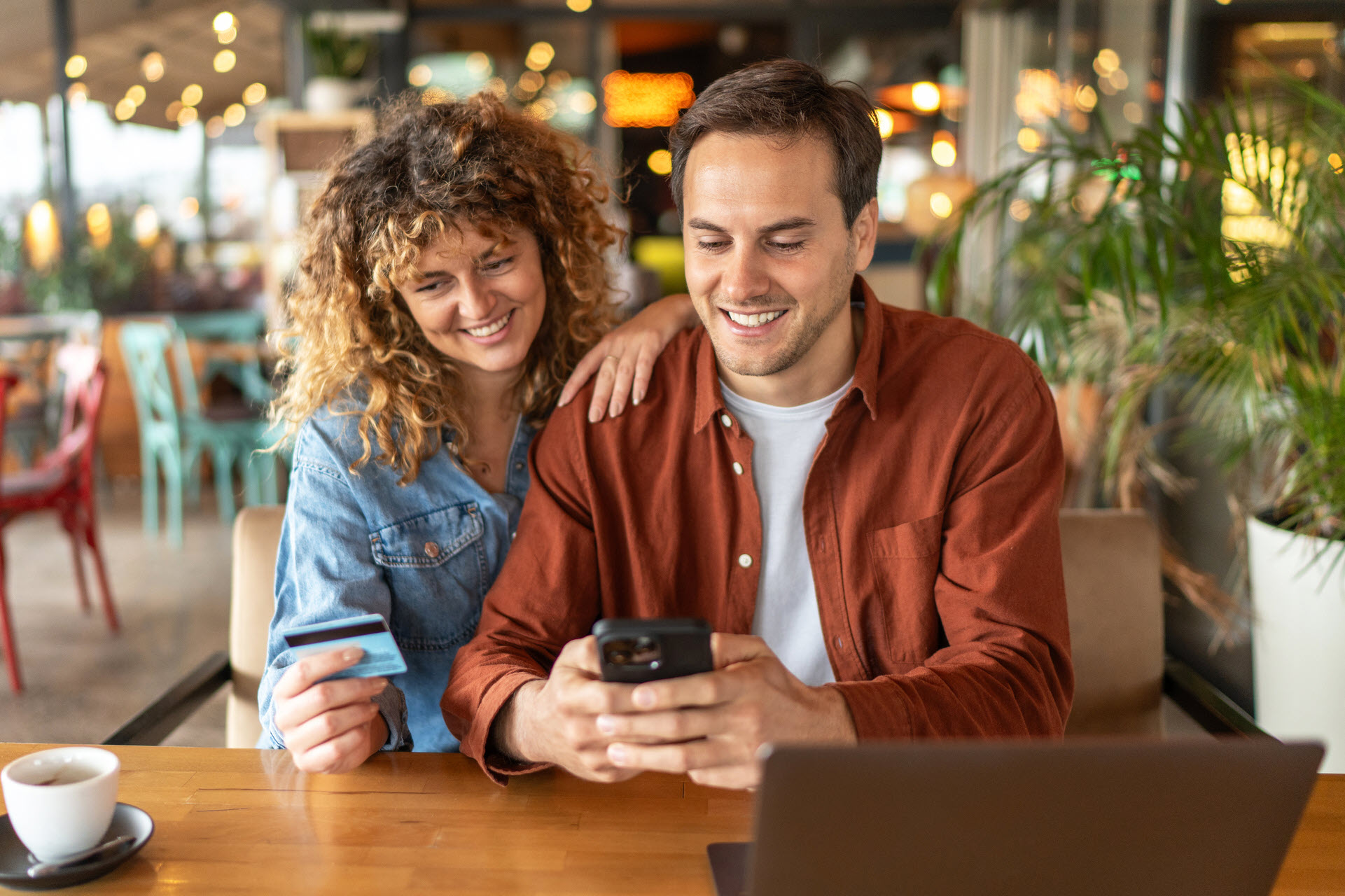Couple Looking At Card And Phone