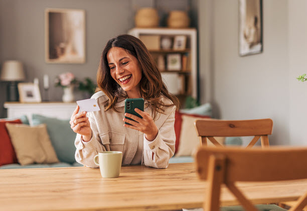 Woman At Table With Card And Phone