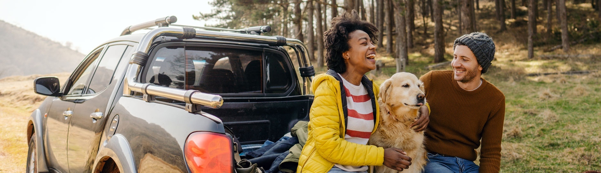 Couple on tailgate of truck with dog