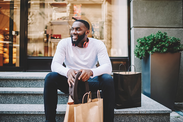 Man sitting with shopping bags on stairs