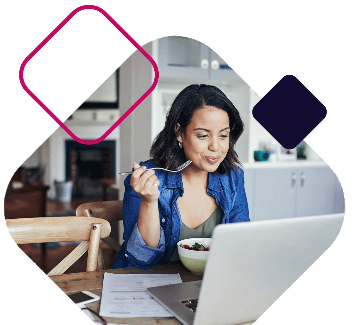 Woman eating breakfast looking at laptop
