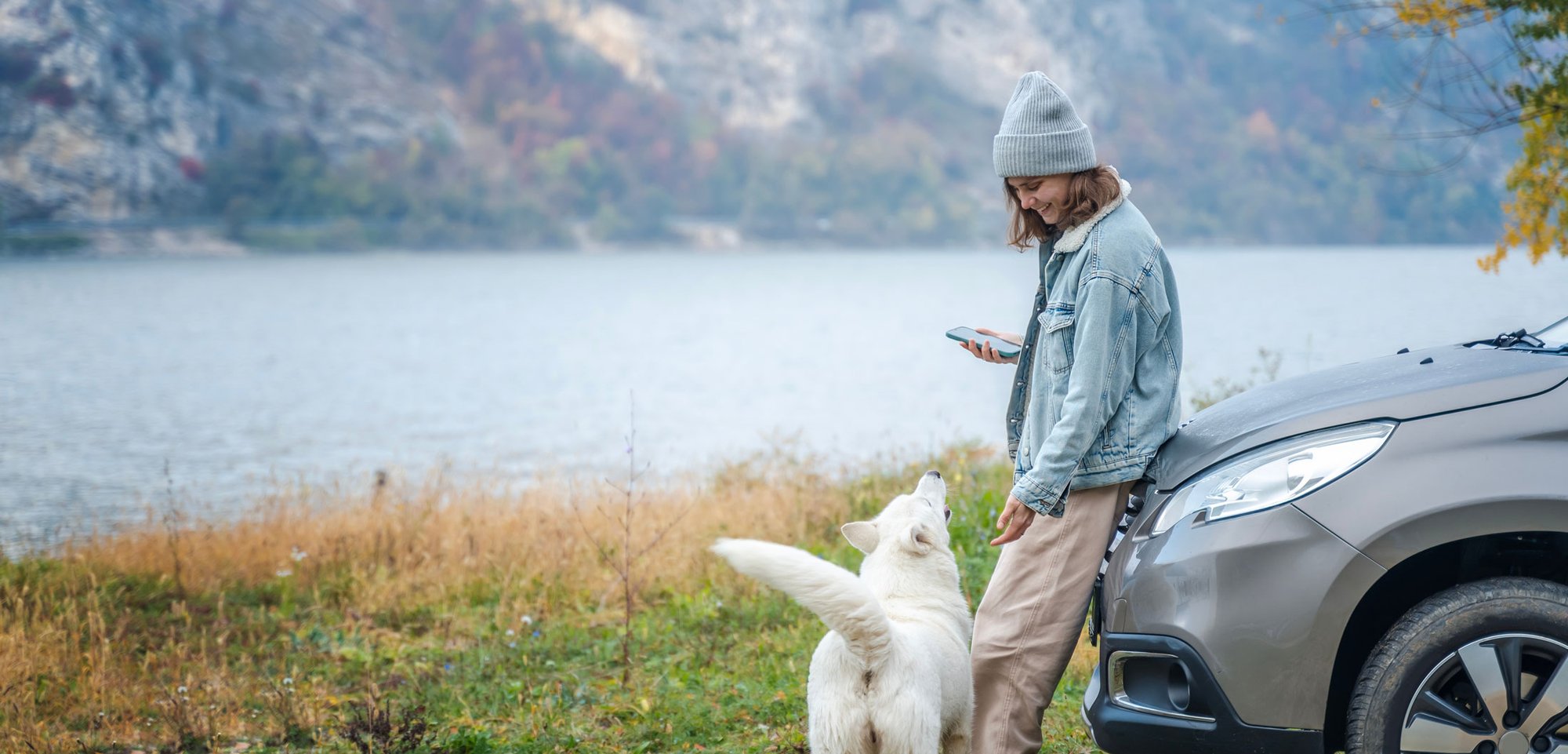 Woman With Beanie and Dog Leaning On Car