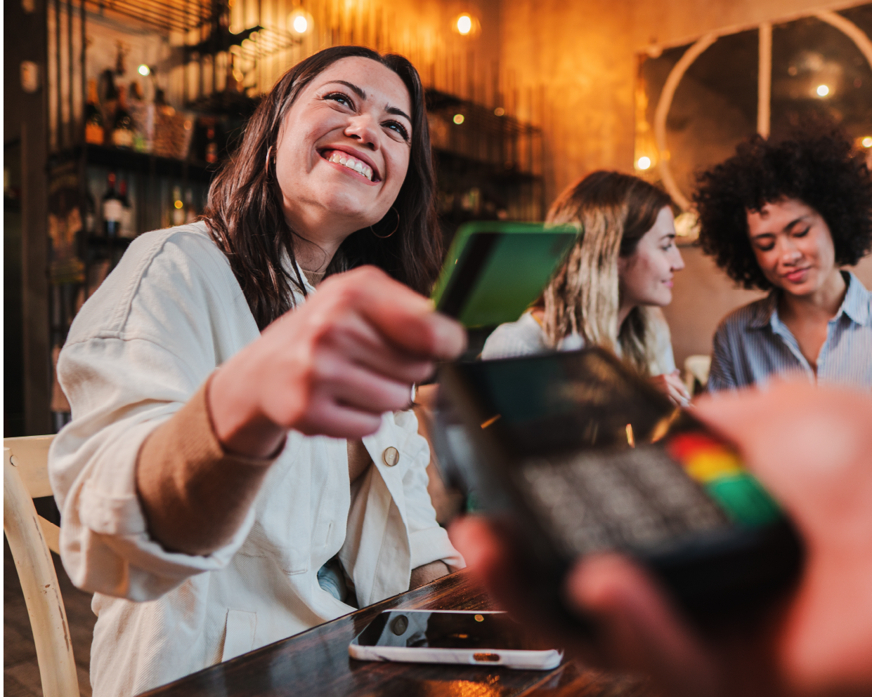 Woman swiping credit card at restaurant