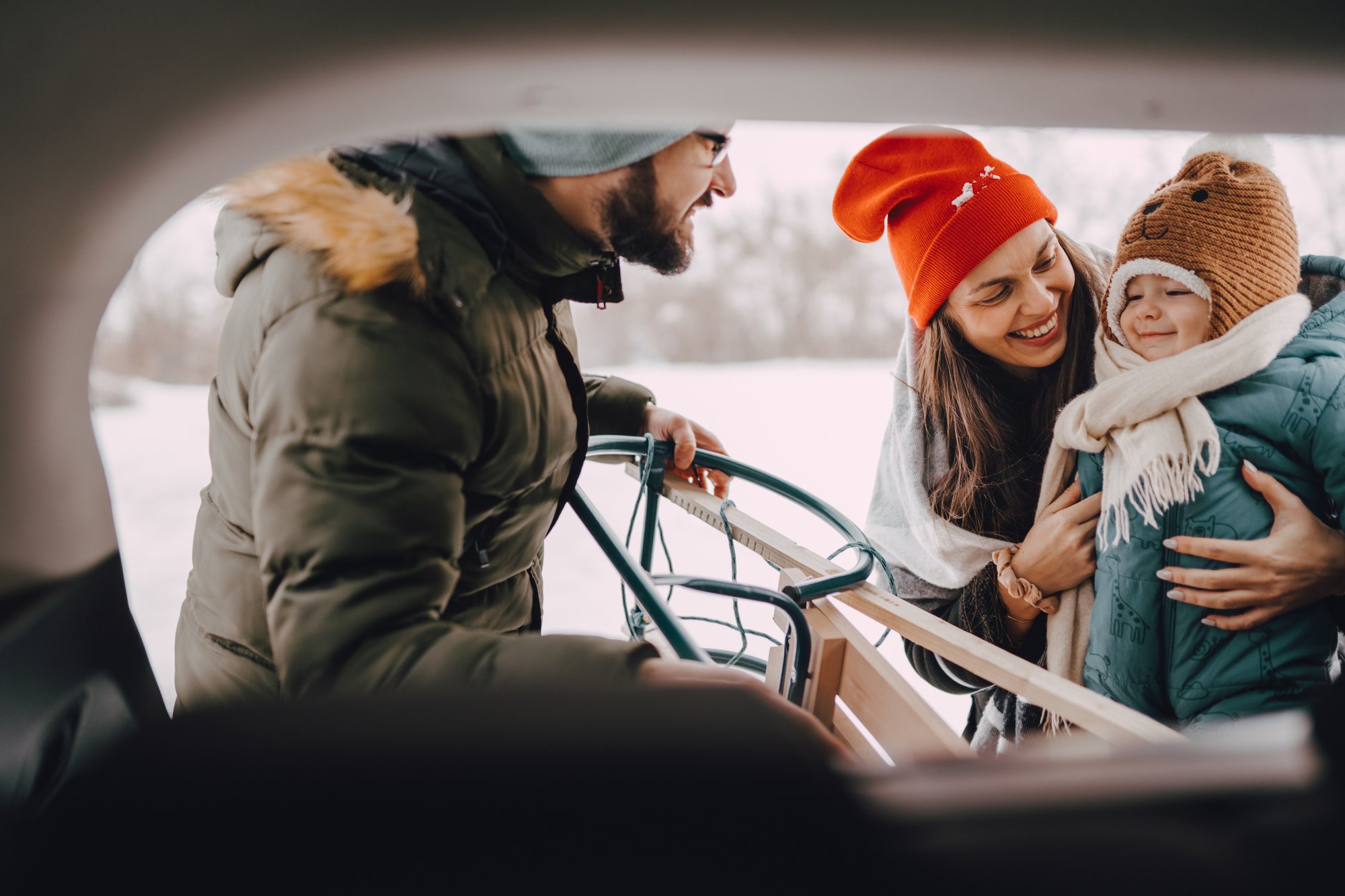 Family Unloading Sled From Car